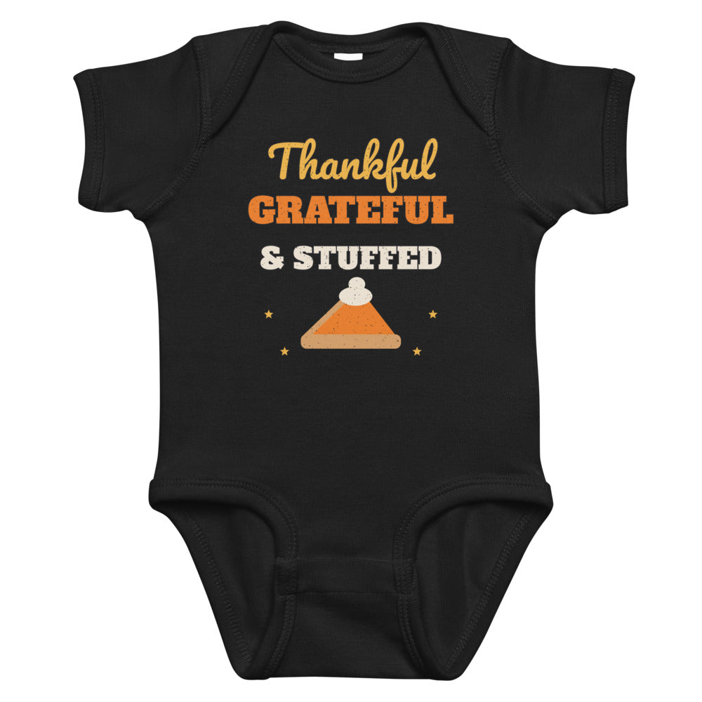 Thankful, Grateful & Stuffed Baby Onesie in black, mockup of the design printed on the front of the baby onesie