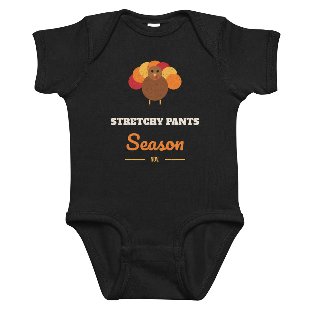 Stretchy Pants Season Baby Onesie in black, mockup of the design printed on the front of the baby onesie