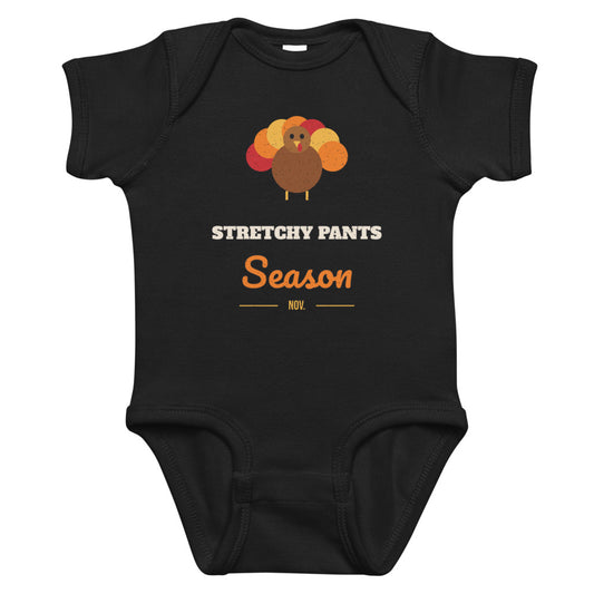 Stretchy Pants Season Baby Onesie in black, mockup of the design printed on the front of the baby onesie