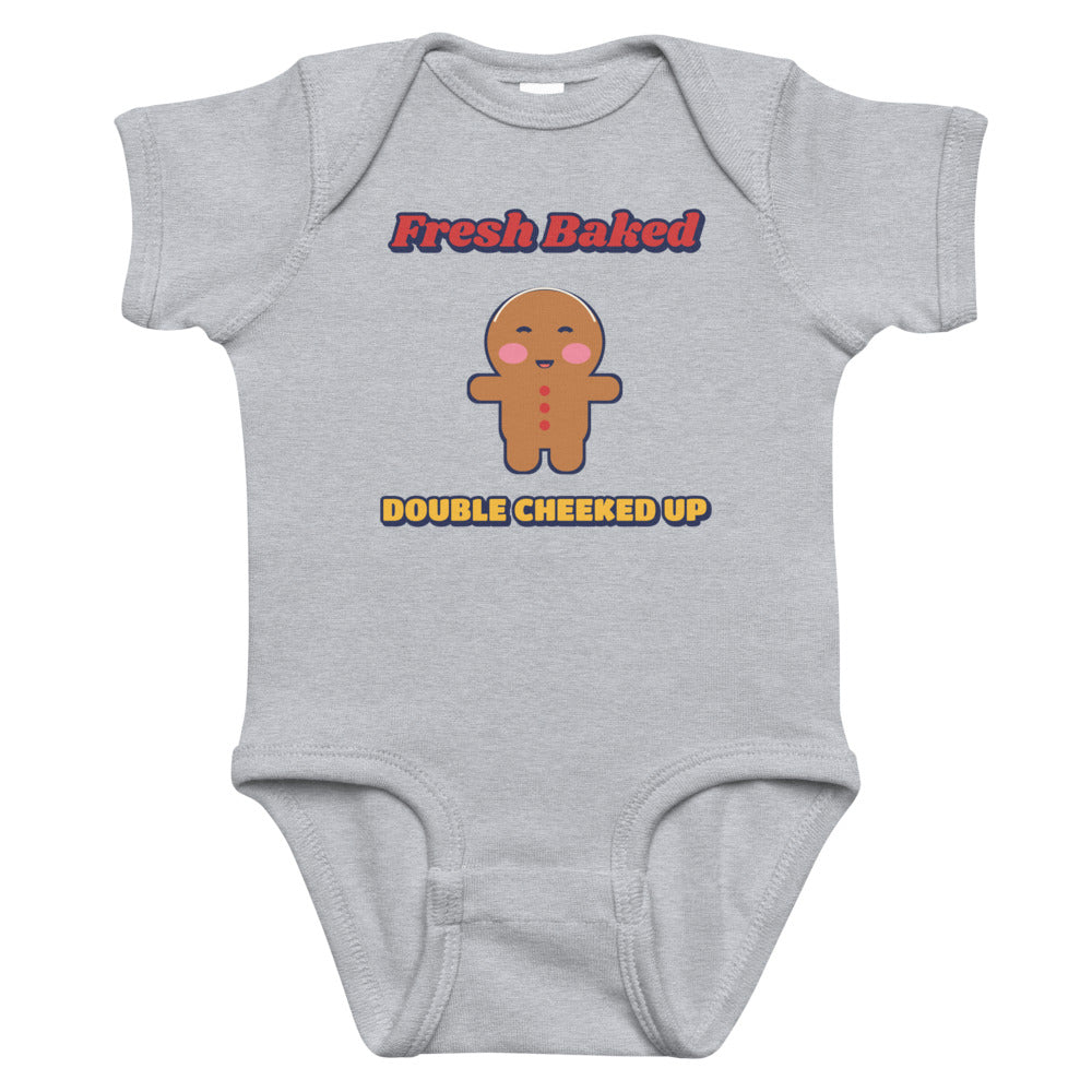 Double Cheeked Up Fresh Baked Gingerbread Baby Onesie in heather, mockup of the design printed on the front of the baby onesie