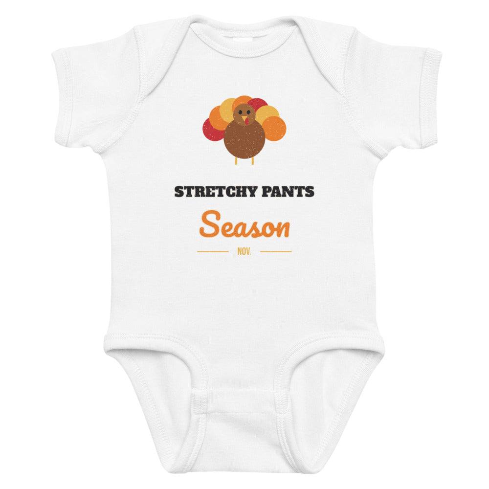Stretchy Pants Season Baby Onesie in white, mockup of the design printed on the front of the baby onesie