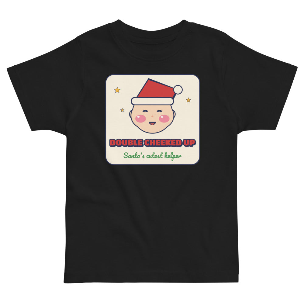 Double Cheeked Up Santa's Cutest Helper Toddler Tee in black, mockup of the design printed on the front of the toddler tee