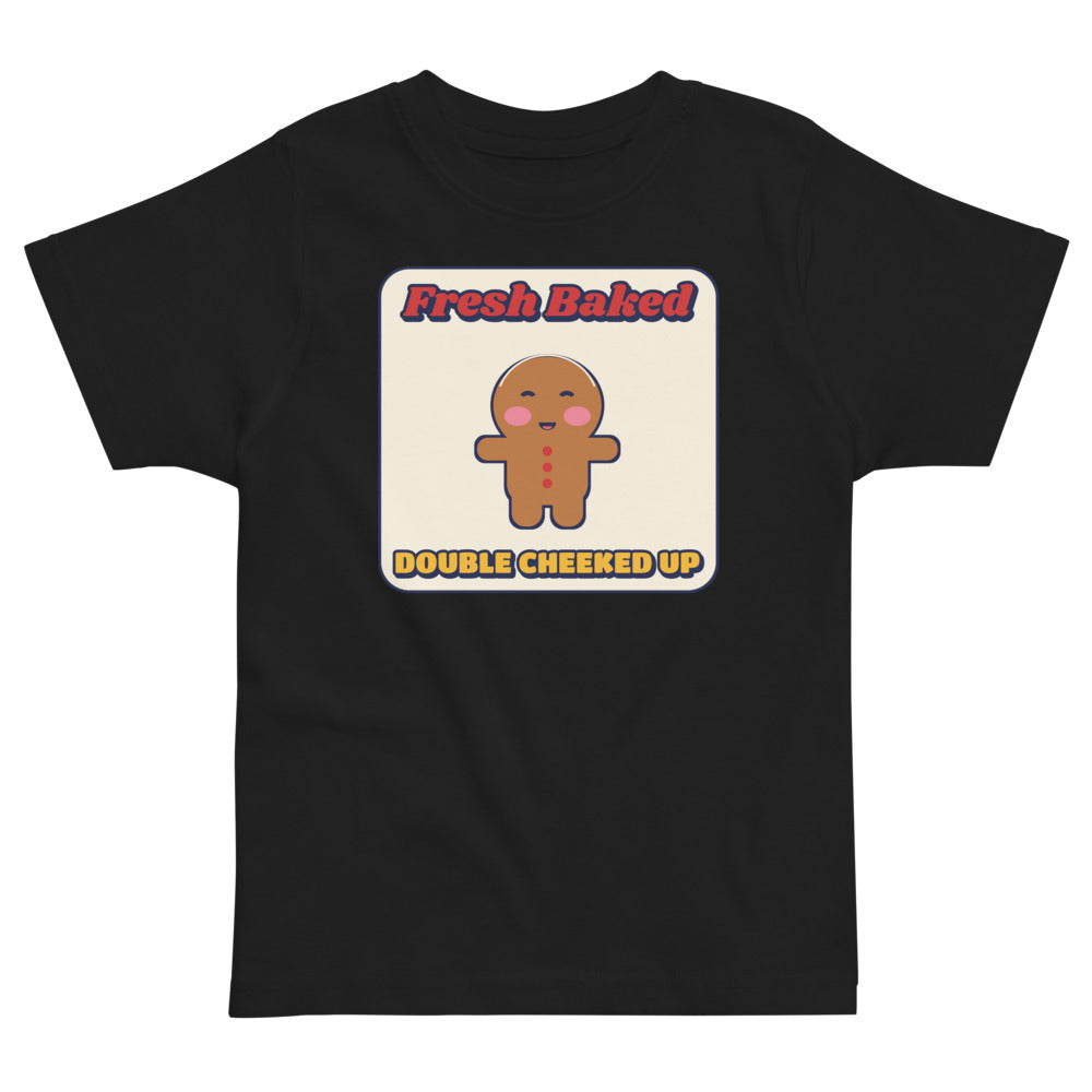 Double Cheeked Up Fresh Baked Gingerbread Toddler Tee in black, mockup of the design printed on the front of the toddler tee