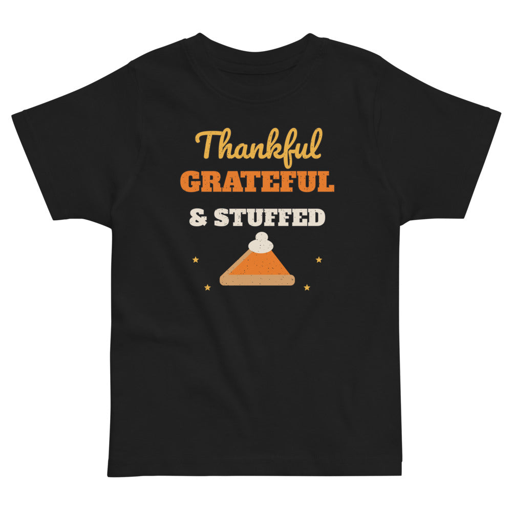 Thankful, Grateful & Stuffed Toddler Tee in black, mockup of the design printed on the front of the toddler tee