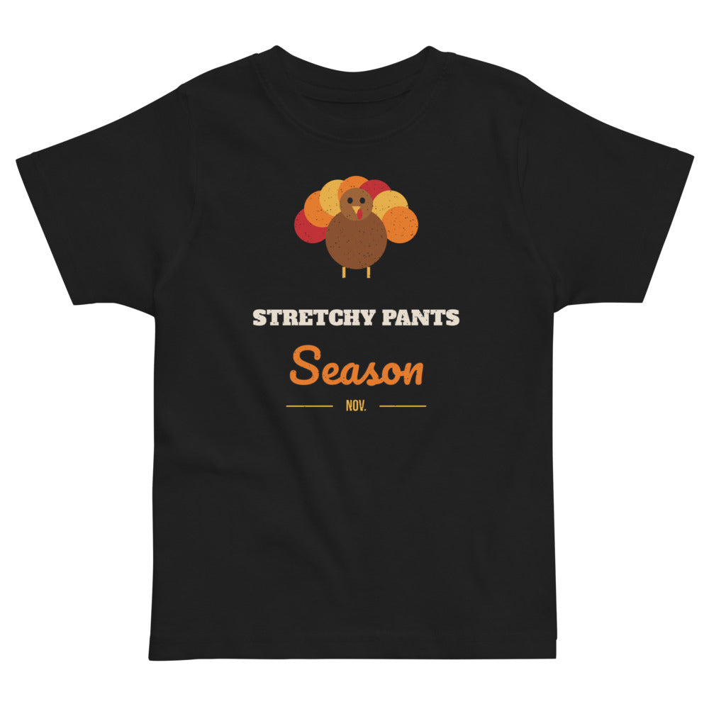 Stretchy Pants Season Toddler Tee in black, mockup of the design printed on the front of the toddler tee