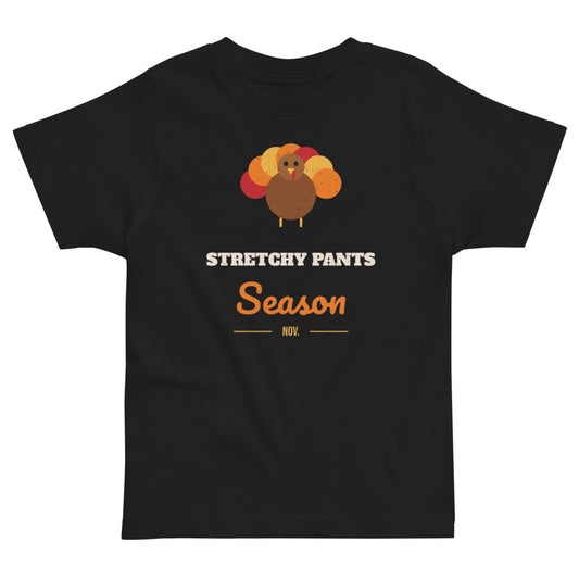 Stretchy Pants Season Toddler Tee in black, mockup of the design printed on the front of the toddler tee