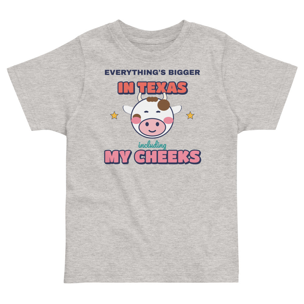 Everything's Bigger in Texas Including My Cheeks Toddler Tee in heather, mockup of the design printed on the front of the toddler tee