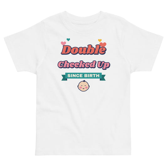 Double Cheeked Up Since Birth Toddler Tee in white, mockup of the design printed on the front of the toddler tee