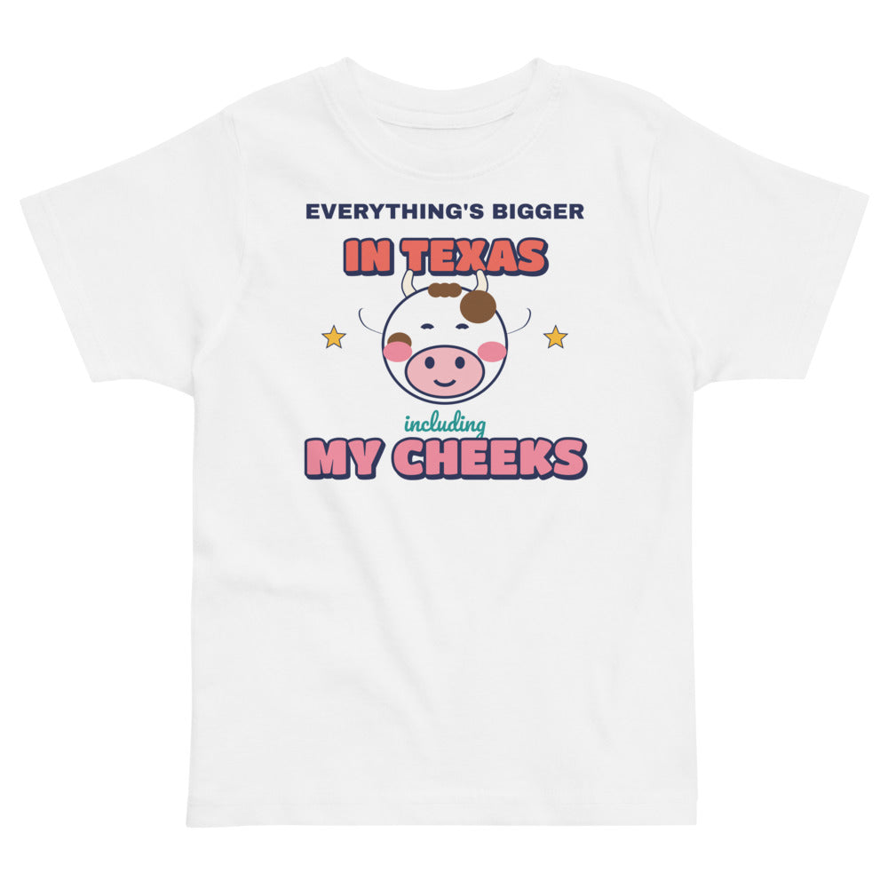 Everything's Bigger in Texas Including My Cheeks Toddler Tee in white, mockup of the design printed on the front of the toddler tee