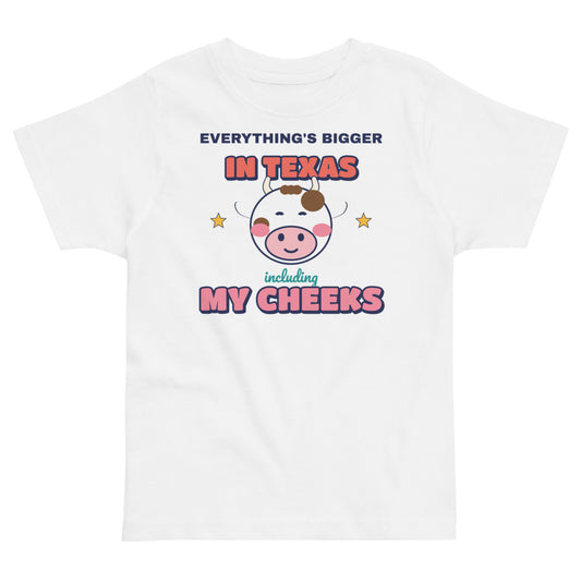 Everything's Bigger in Texas Including My Cheeks Toddler Tee in white, mockup of the design printed on the front of the toddler tee