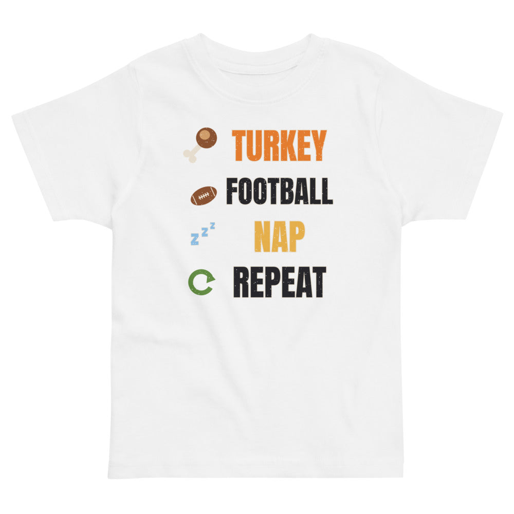 Turkey Football Nap Repeat Toddler Tee in white, mockup of the design printed on the front of the toddler tee