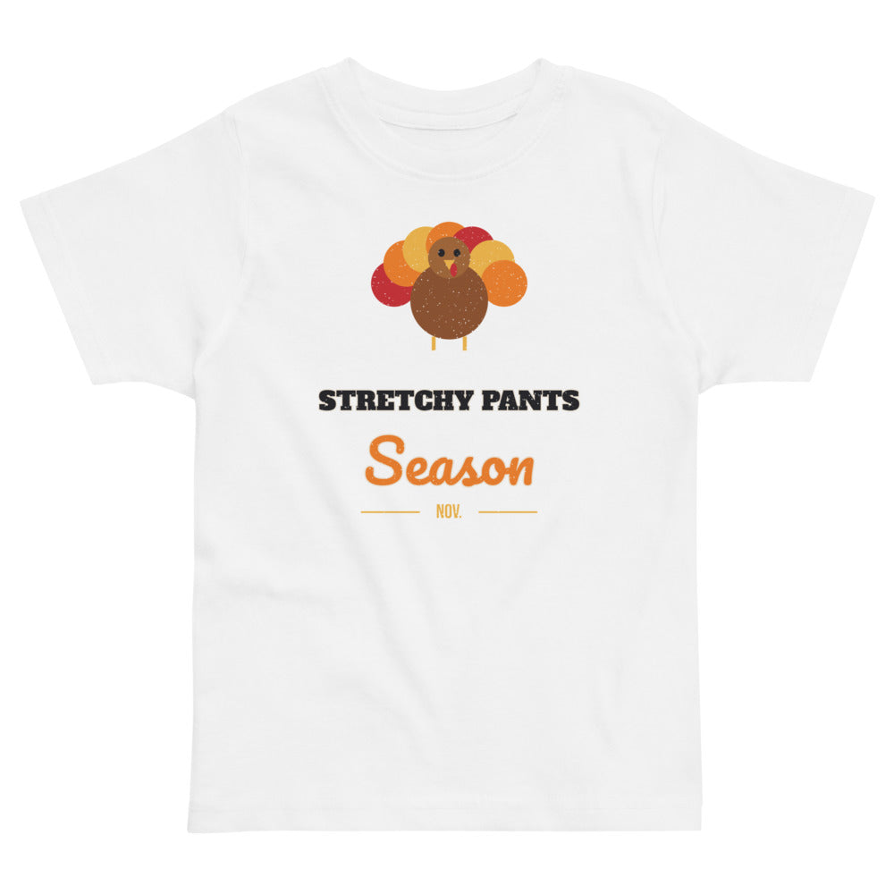Stretchy Pants Season Toddler Tee in white, mockup of the design printed on the front of the toddler tee
